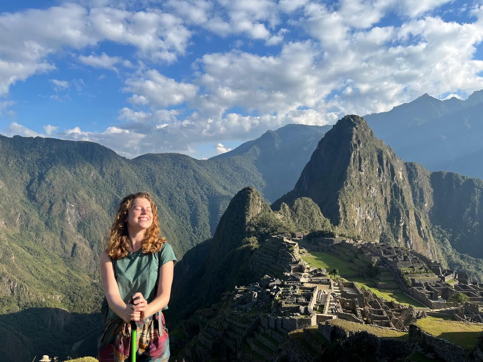 Woman standing in front of Machu Picchu site.