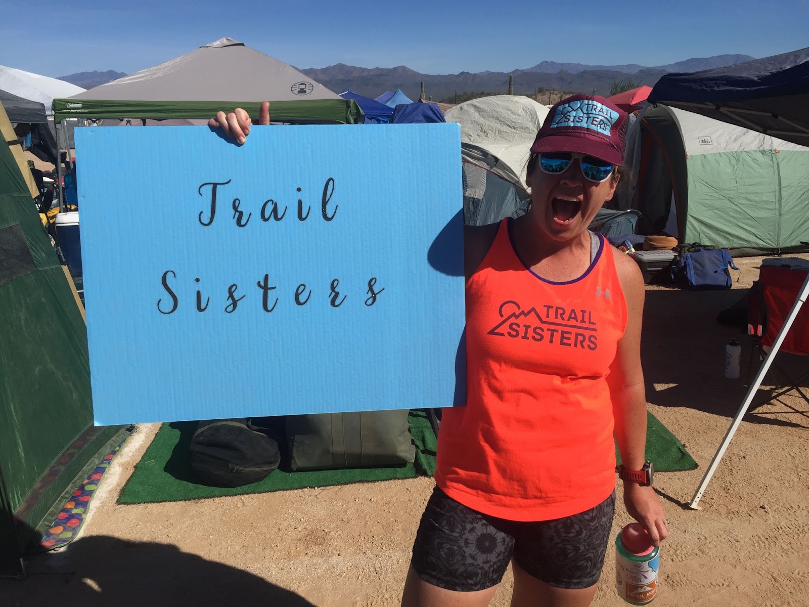 Woman holding a sign that says Trail Sisters