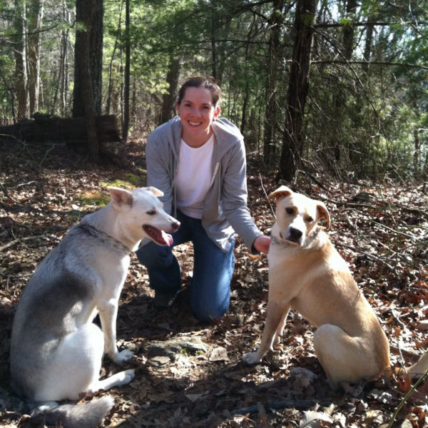 Suzanne Hermann in woods with her two dogs