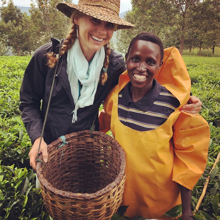 Two women standing in a tea field with a basket