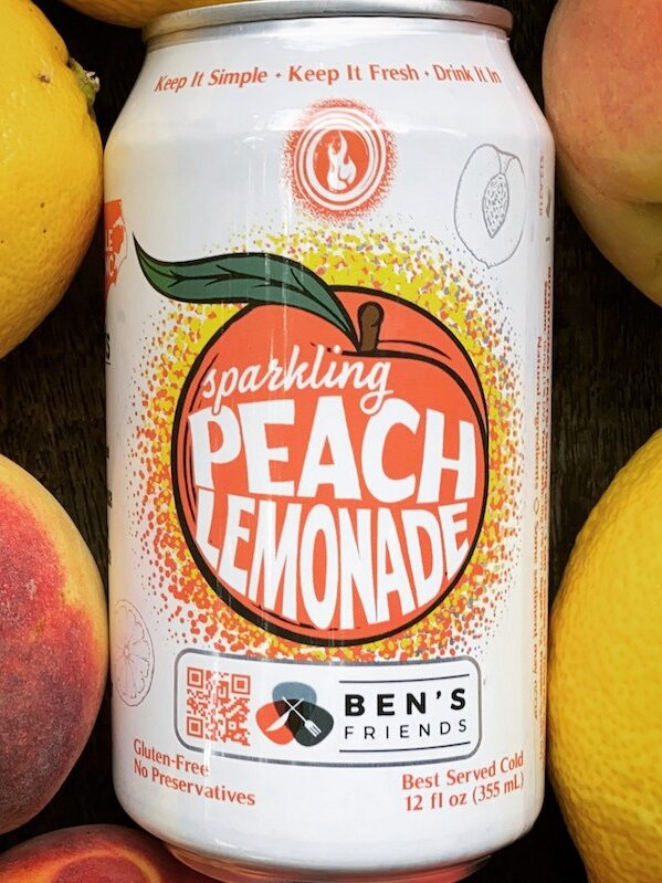 Can of Devil's Foot Peach Lemonade surrounded by lemons and peaches